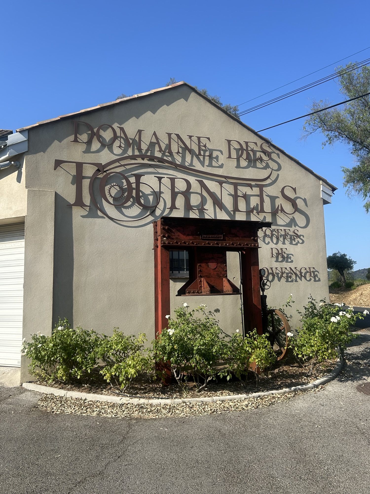 Façade du Domaine des Tournels à Ramatuelle avec pressoir ancien exposé devant le bâtiment